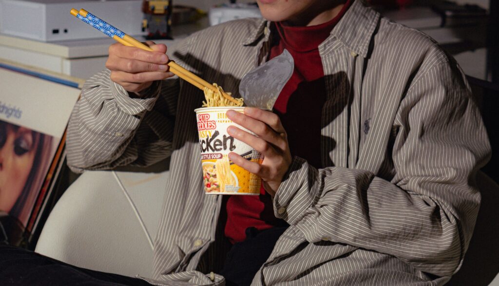 Person eating instant noodles